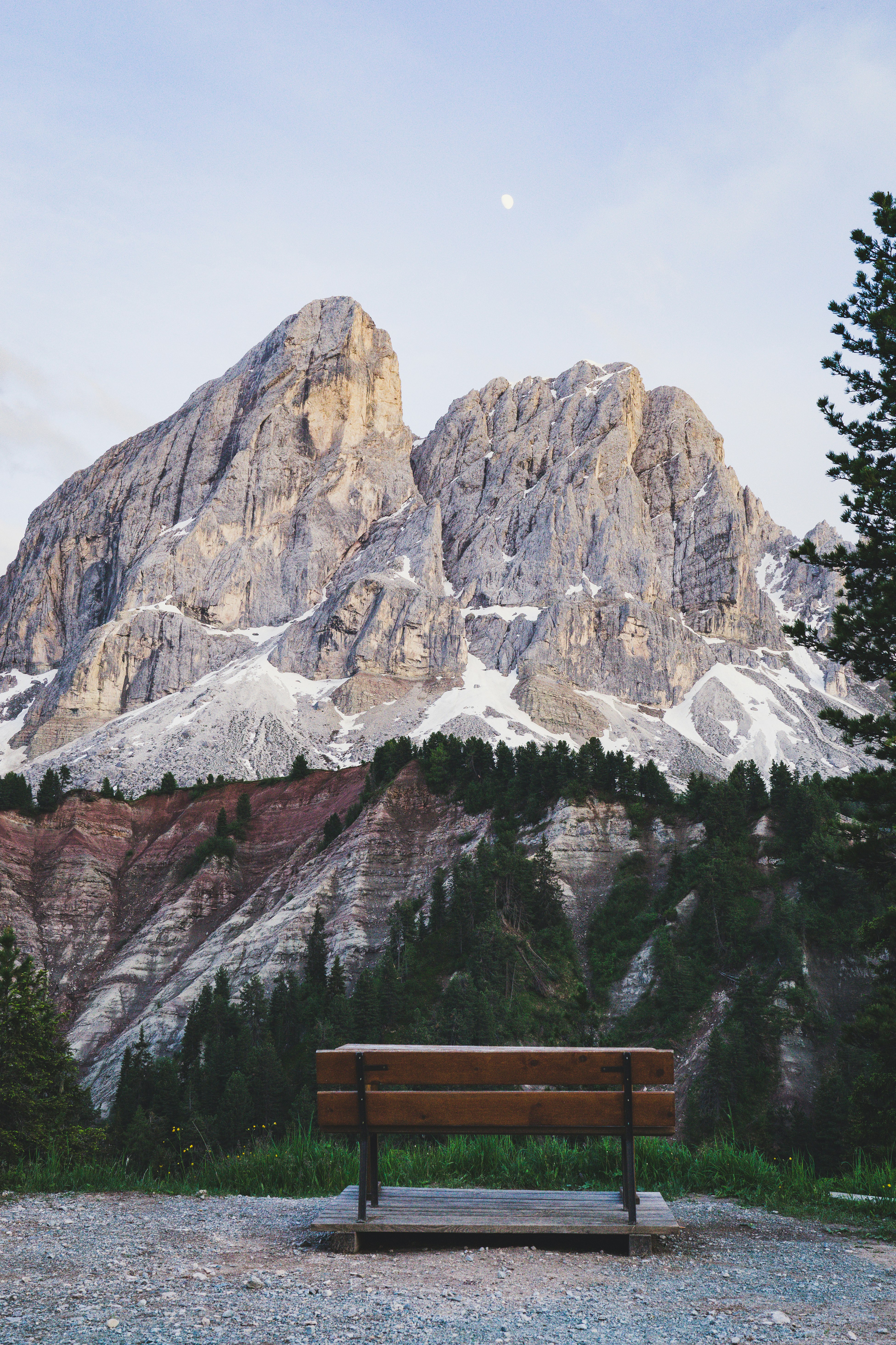 brown wooden bench near snow covered mountain during daytime